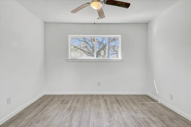 an empty room with a chandelier fan