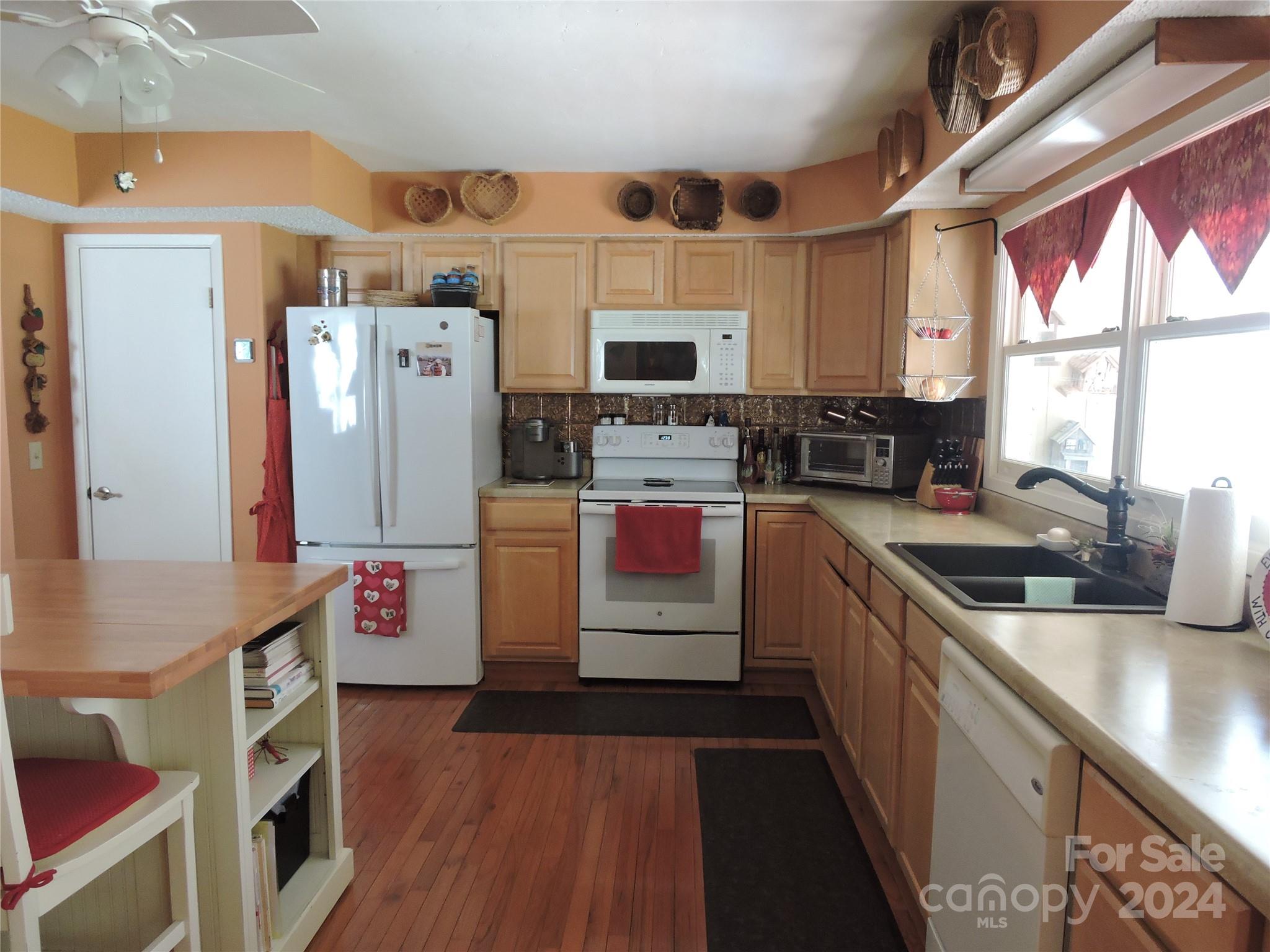 329 Riddle Cove Road Maggie Valley, NC 28751 - Photo 2 of 22 a kitchen with stainless steel appliances a stove top oven a refrigerator a sink dishwasher and wooden cabinets with wooden floor
