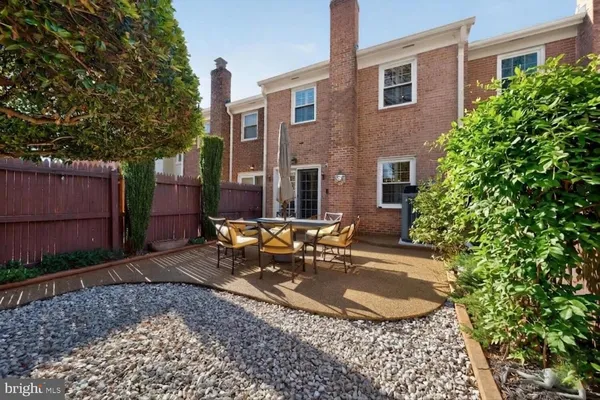a view of patio with table and chairs potted plants and a large tree