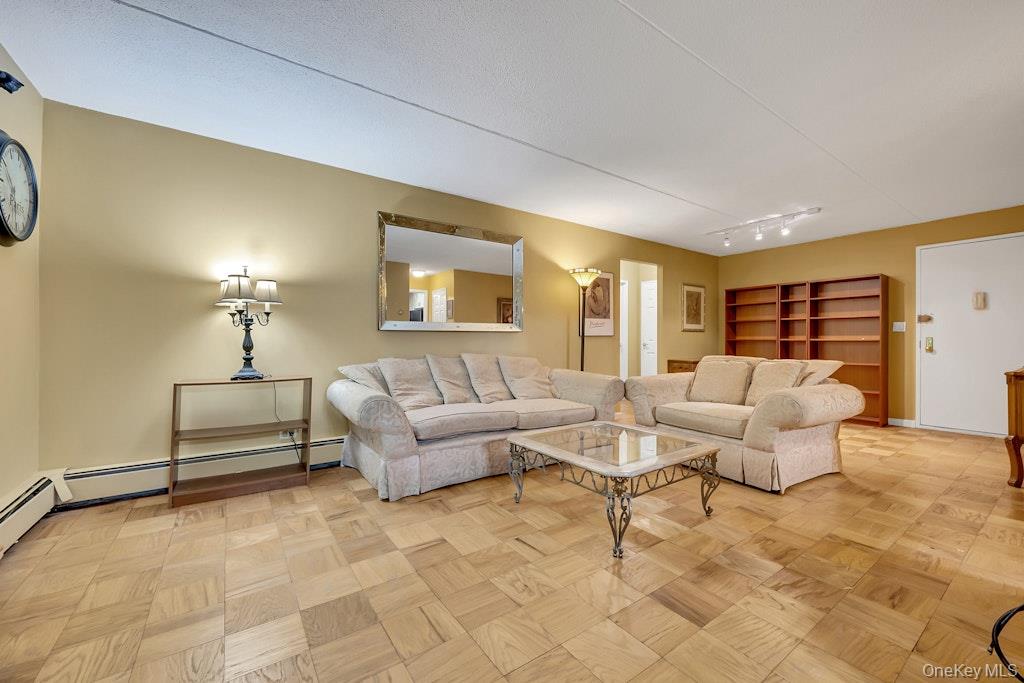 108 Sagamore Road, Unit 5E Tuckahoe, NY 10707 - Photo 8 of 23 a living room with furniture and a chandelier