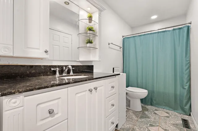 a bathroom with a sink a toilet a mirror and vanity