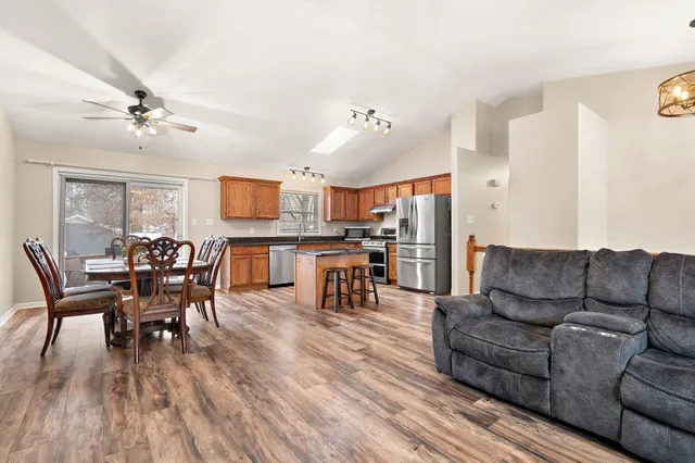 a living room with furniture wooden floor and kitchen view