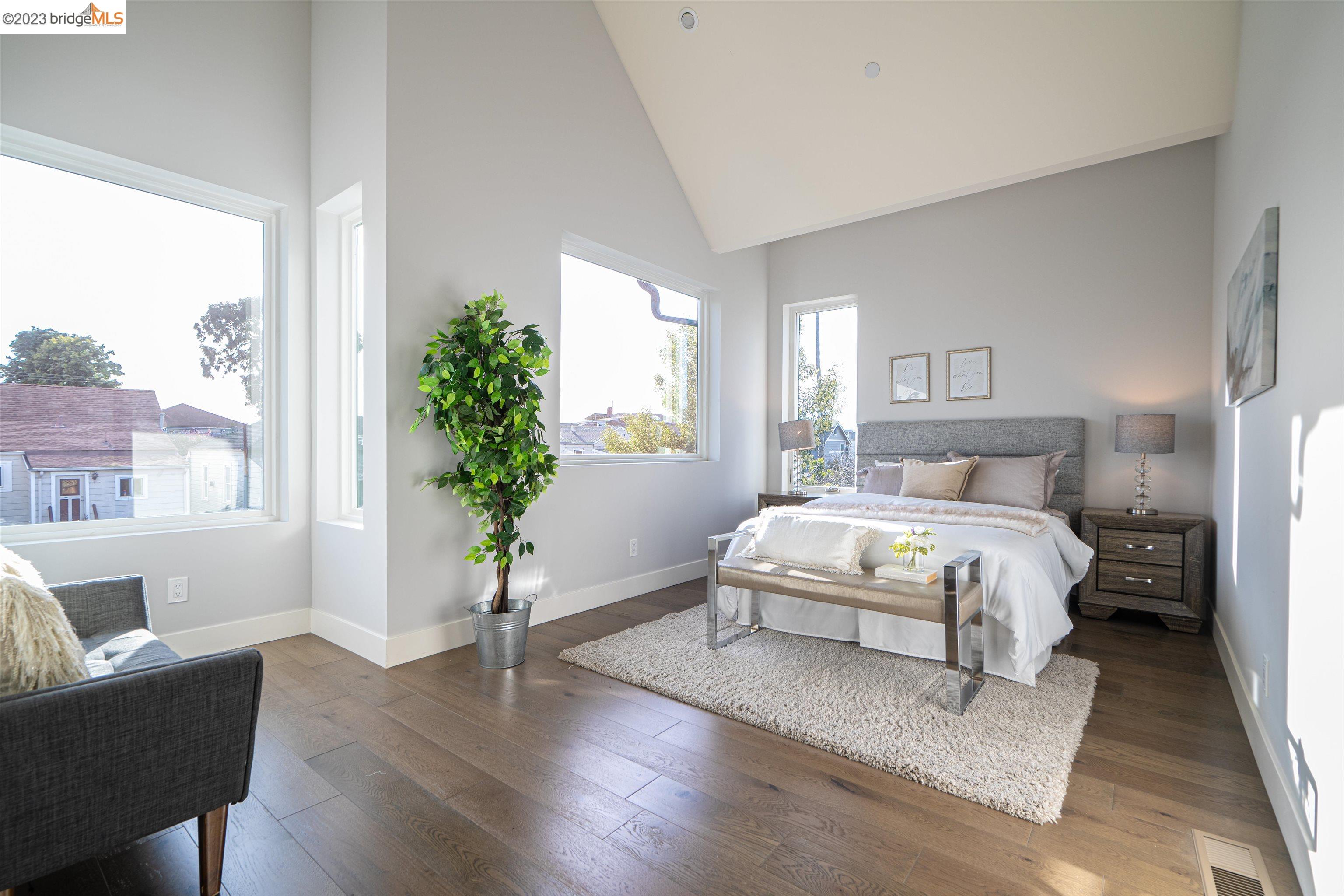 1679 12th Street Oakland, CA 94607 - Photo 18 of 26 a spacious bedroom with a bed and a potted plant