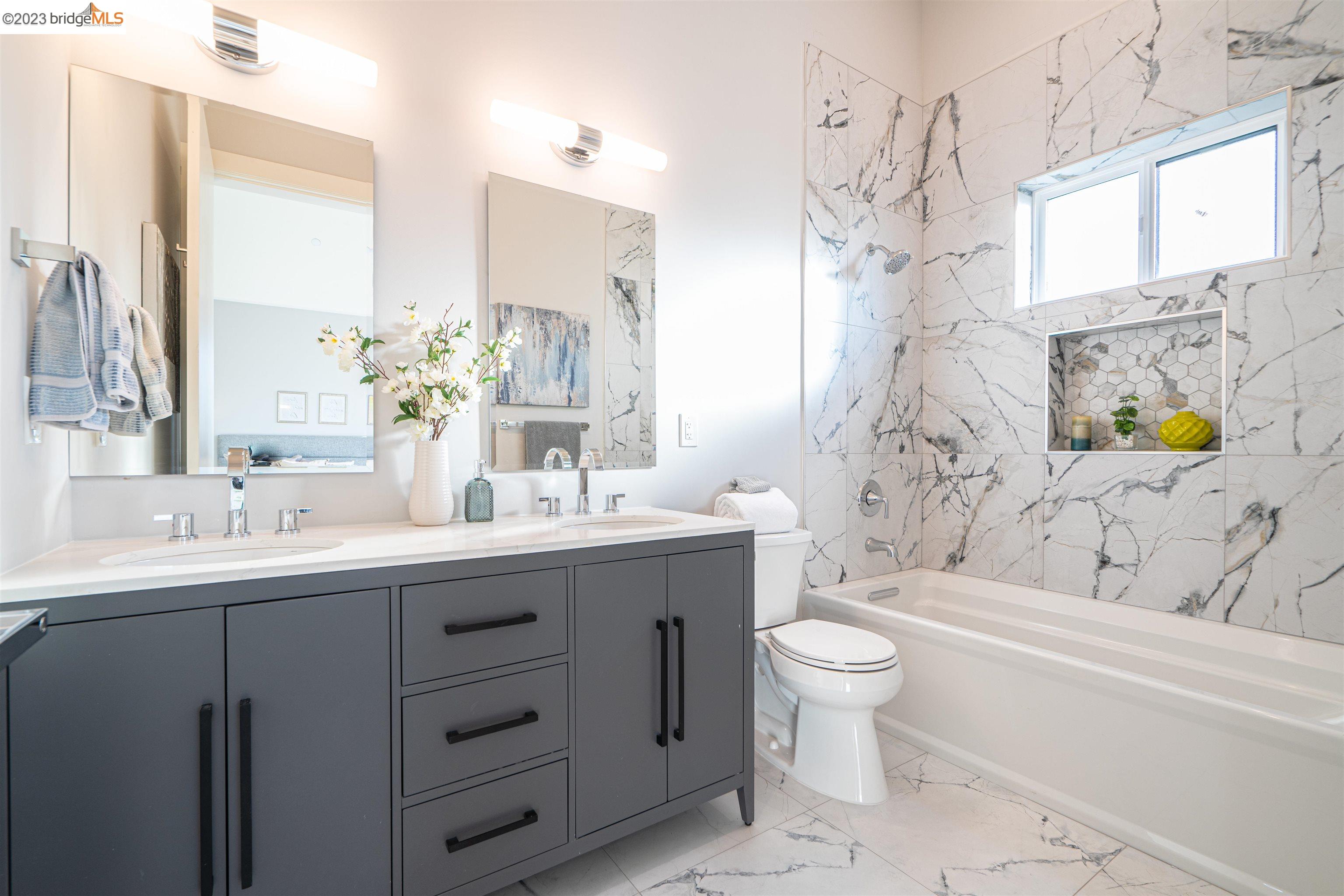 1679 12th Street Oakland, CA 94607 - Photo 20 of 26 a bathroom with a double vanity sink toilet and shower