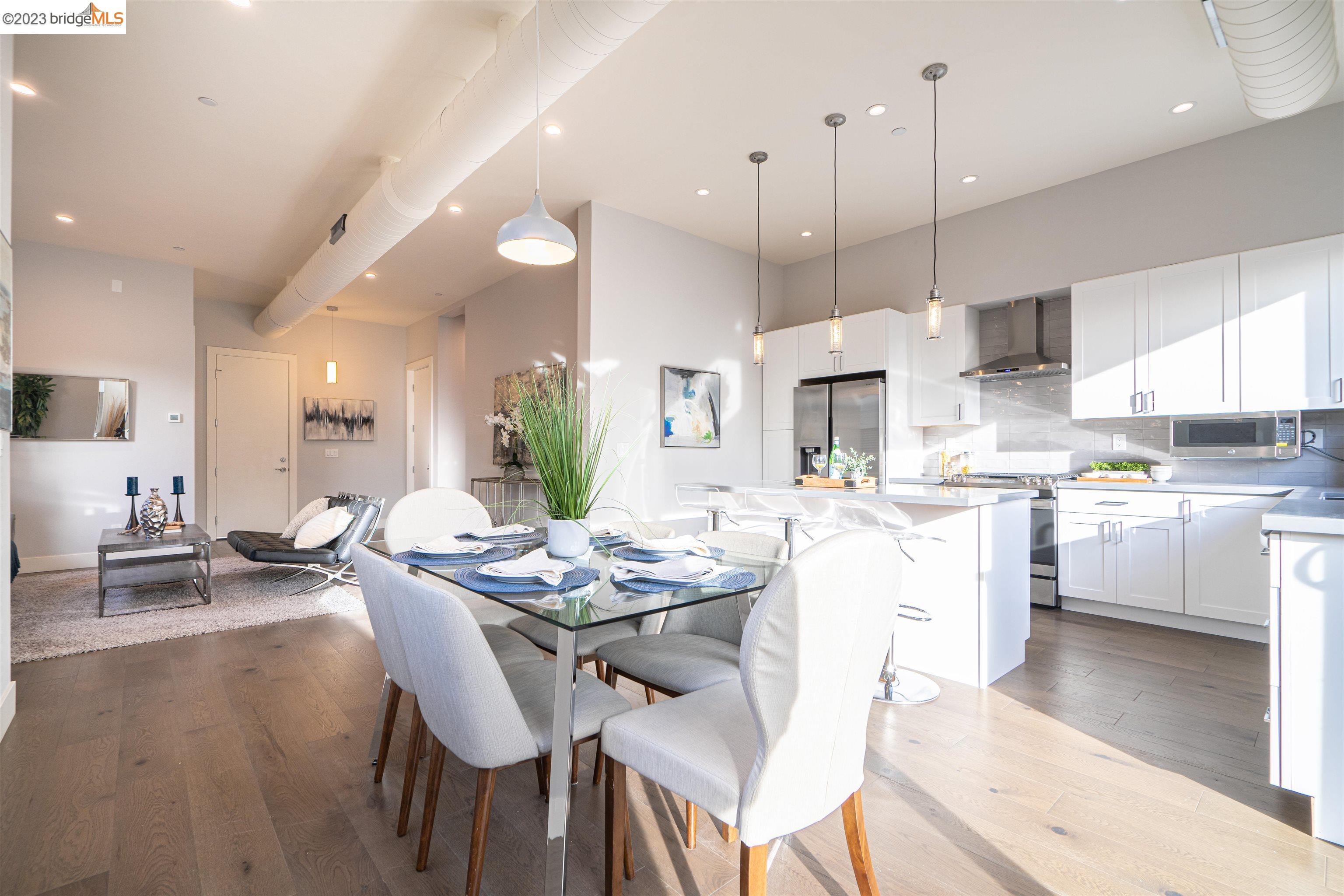 1679 12th Street Oakland, CA 94607 - Photo 6 of 26 a dining room with stainless steel appliances kitchen island granite countertop a stove a sink a dining table and chairs with wooden floor