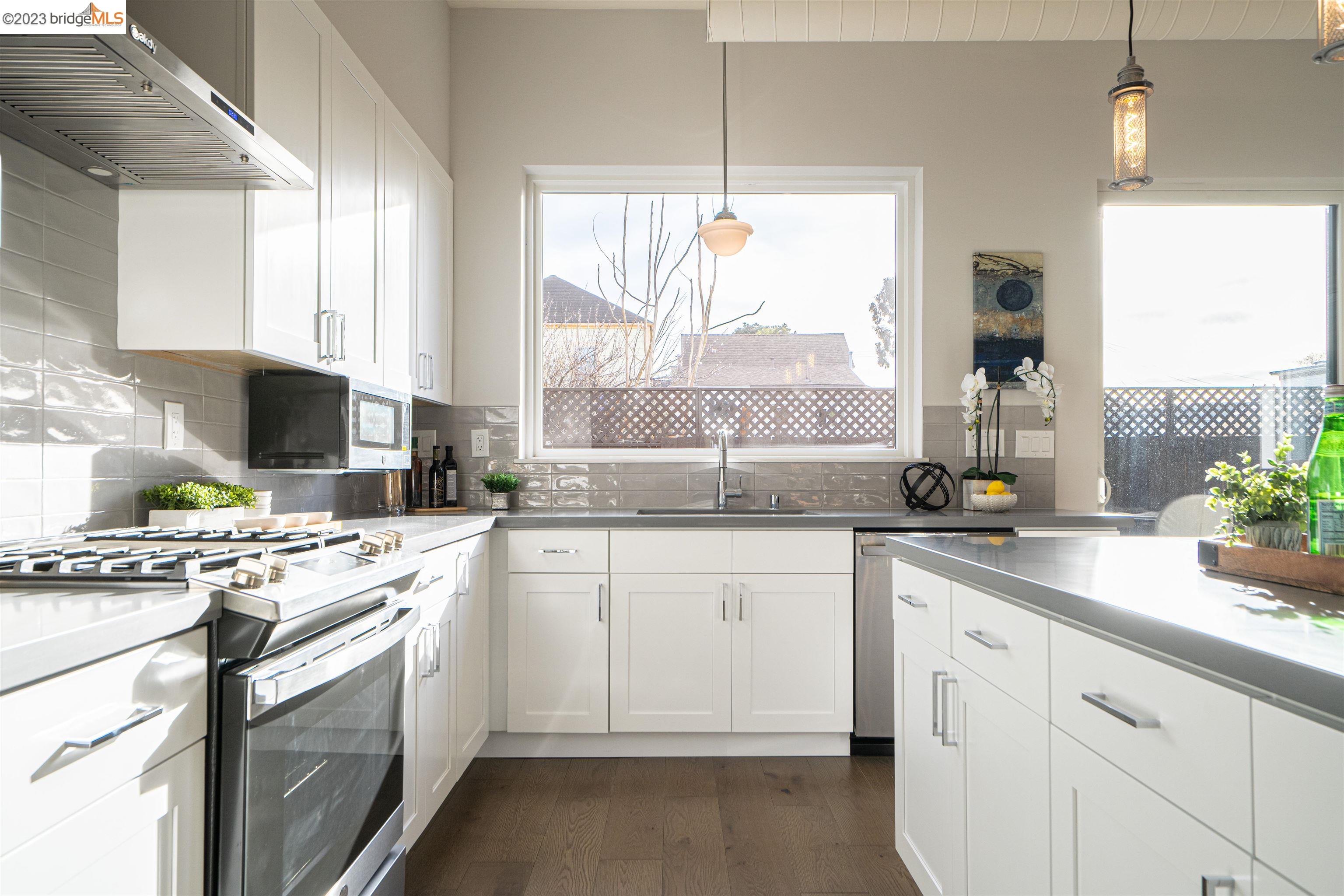 1679 12th Street Oakland, CA 94607 - Photo 8 of 26 a kitchen with a white stove top oven sink and cabinets