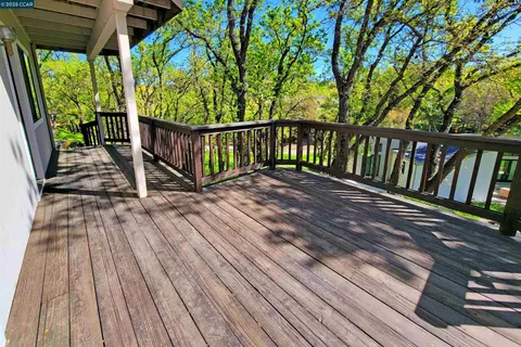 a view of balcony with wooden floor and fence