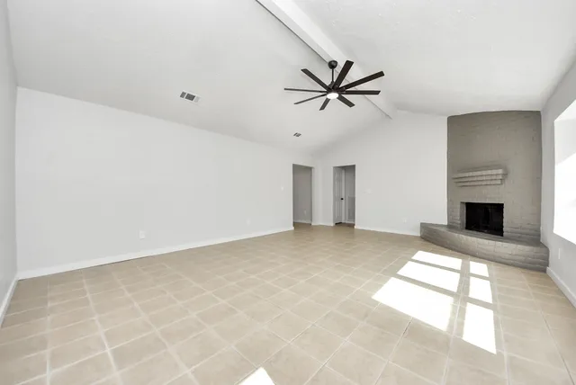 a view of an empty room with a fireplace and a window