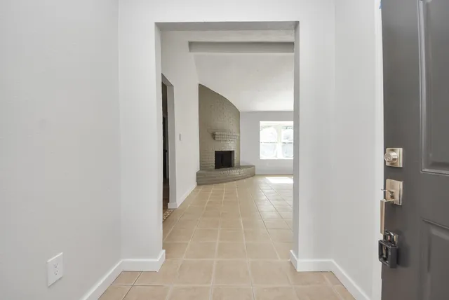 a view of a hallway view with wooden floor and a bathroom