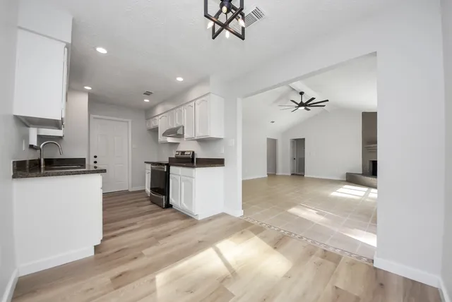 a kitchen with a refrigerator and a stove top oven