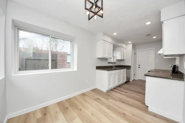 a kitchen with granite countertop a stove a sink and a refrigerator
