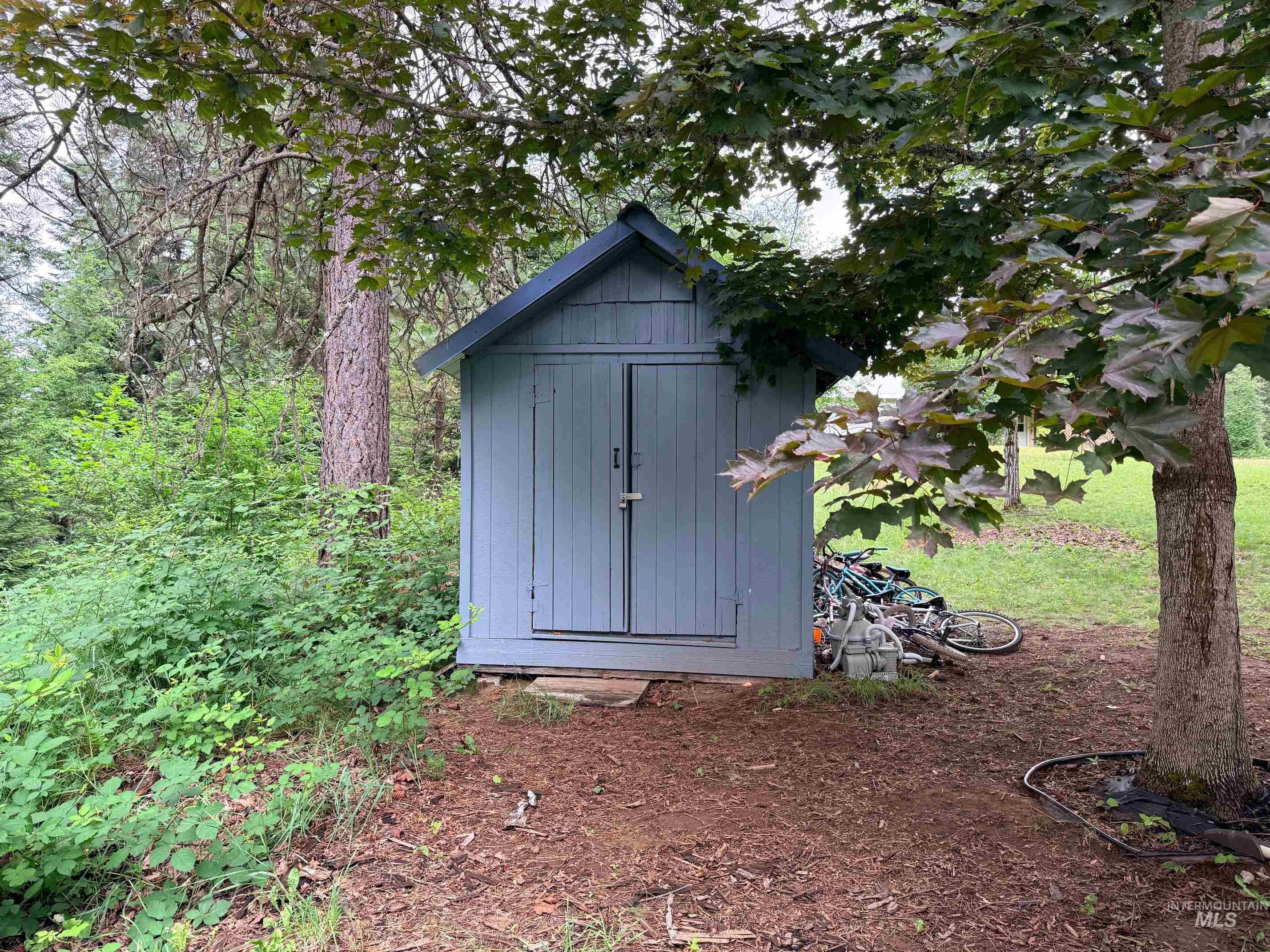 5742 Grangemont Road Orofino, ID 83544 - Photo 24 of 25 Wood-sided storage shed with a dark-pitched roof and double doors
