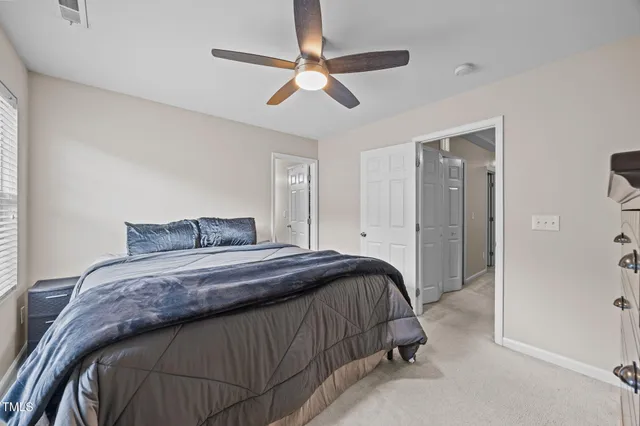 a bedroom with a bed and a ceiling fan