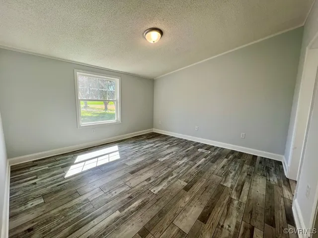 a view of an empty room and window and wooden floor