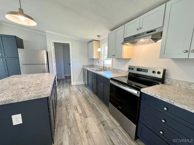 a kitchen with granite countertop stainless steel appliances and wooden cabinets