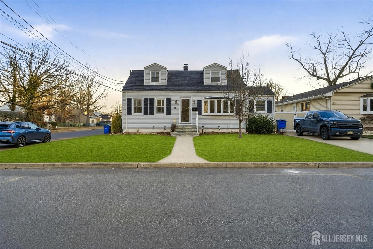 a view of house with a yard and large trees