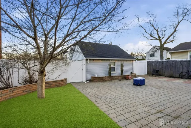 a view of a house with backyard and trees