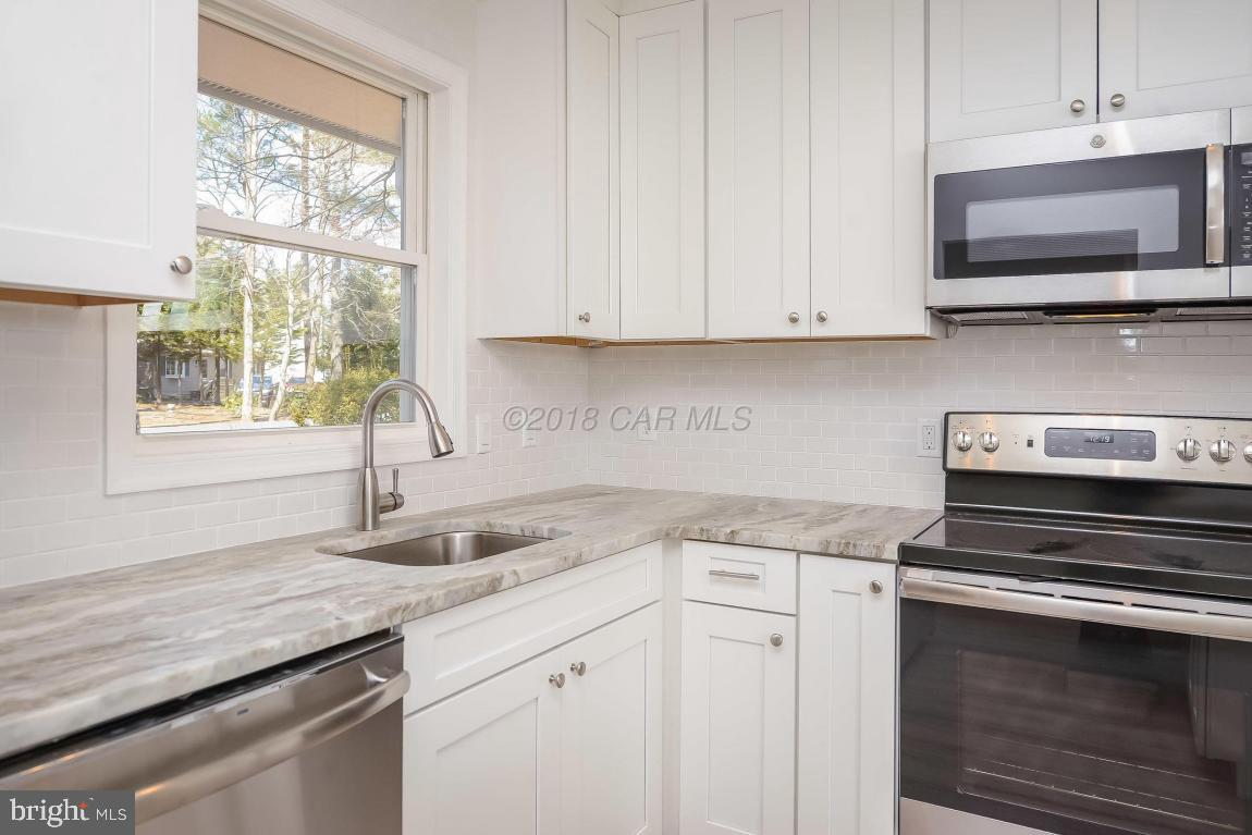 45 Abbyshire Road Ocean Pines, MD 21811 - Photo 15 of 37 a kitchen with granite countertop a stove sink and microwave