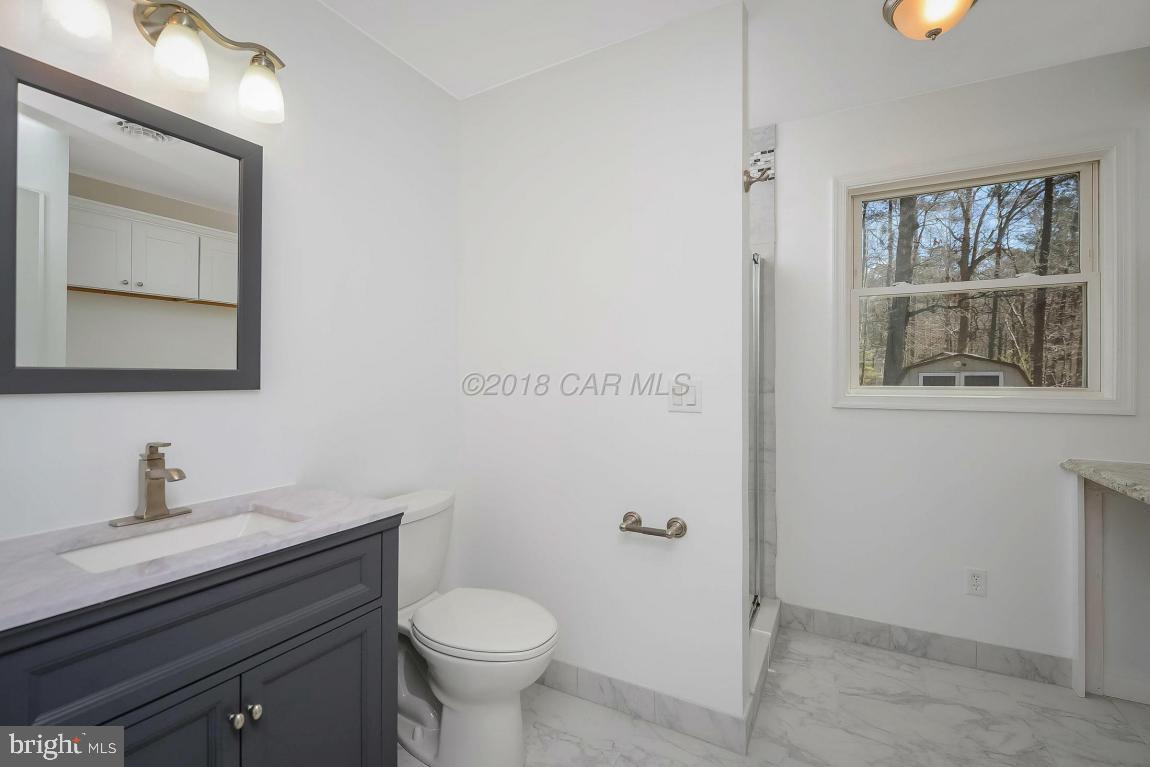 45 Abbyshire Road Ocean Pines, MD 21811 - Photo 19 of 37 a bathroom with a toilet a sink a mirror and a window