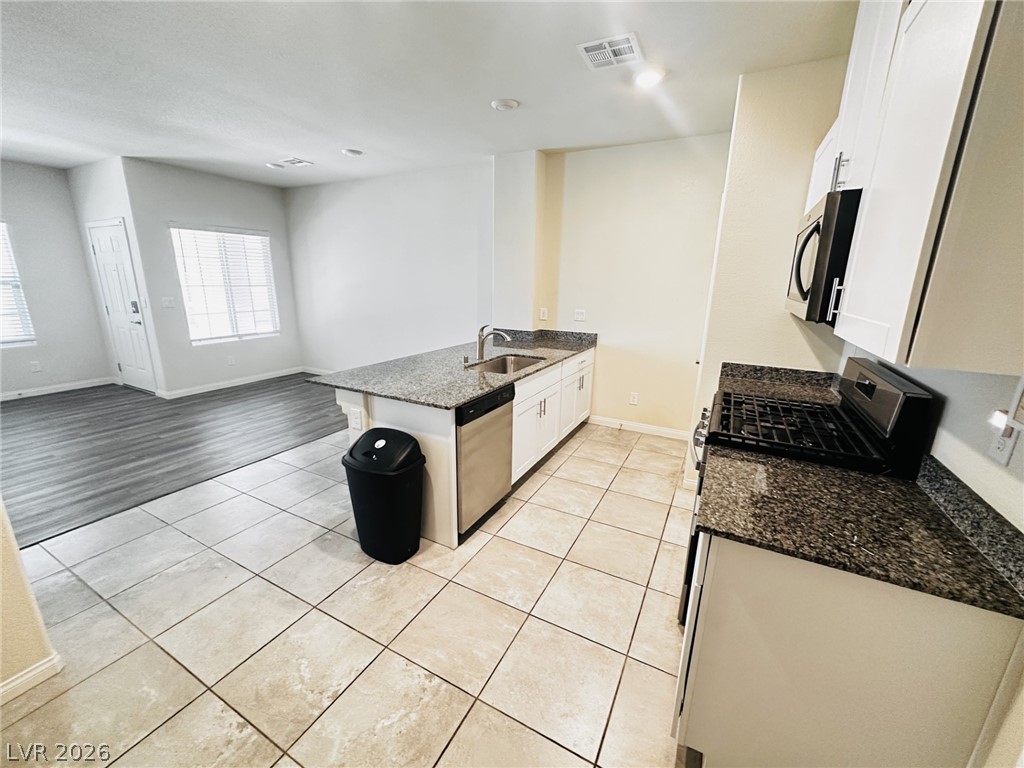 7331 Sunray Point Street North Las Vegas, NV 89084 - Photo 3 of 20 The open-concept design seamlessly connects the kitchen with a bright living area, creating an inviting atmosphere.