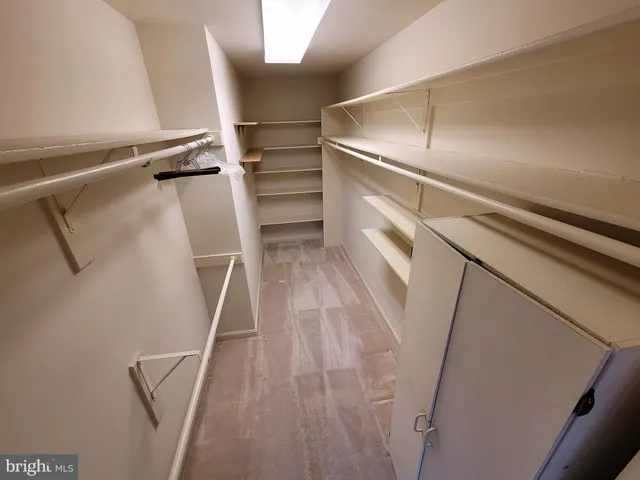 a view of walk in closet with empty racks