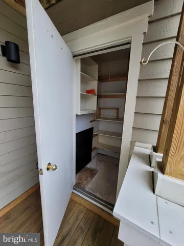 a view of an empty room with wooden floor and staircase