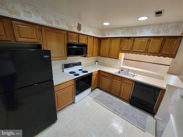 a kitchen with stainless steel appliances granite countertop a refrigerator stove a sink dishwasher and microwave oven