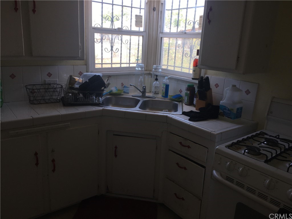 a kitchen with a sink a stove cabinets and a window