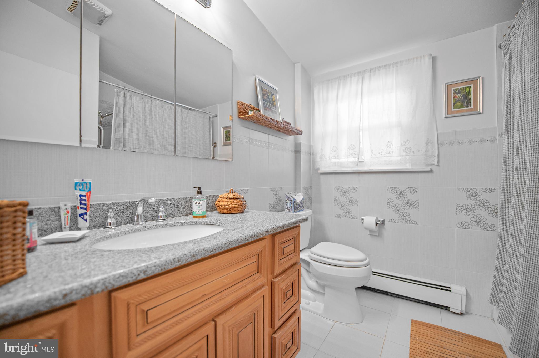 2409 Ashbourne Road Wyncote, PA 19095 - Photo 17 of 36 a bathroom with a granite countertop sink a toilet and a mirror