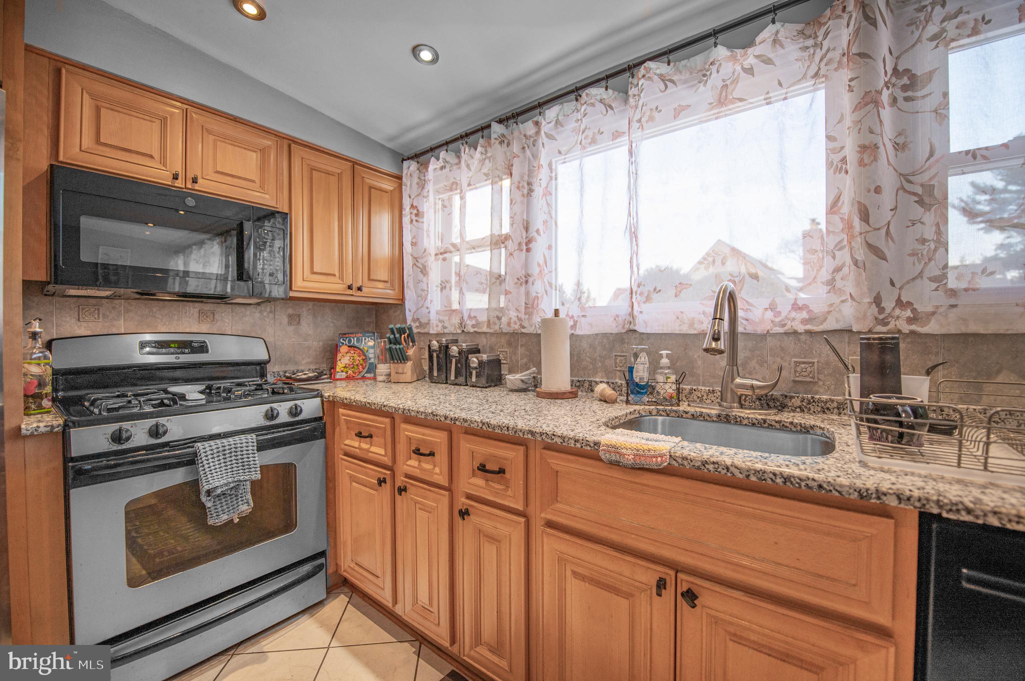 2409 Ashbourne Road Wyncote, PA 19095 - Photo 2 of 36 a kitchen with granite countertop a stove a sink and a microwave