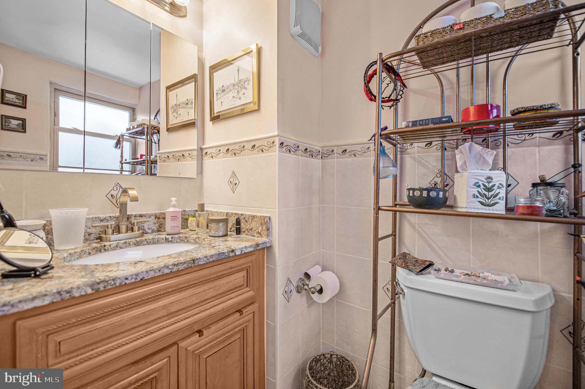 2409 Ashbourne Road Wyncote, PA 19095 - Photo 26 of 36 a bathroom with a granite countertop sink a toilet and a shower curtain