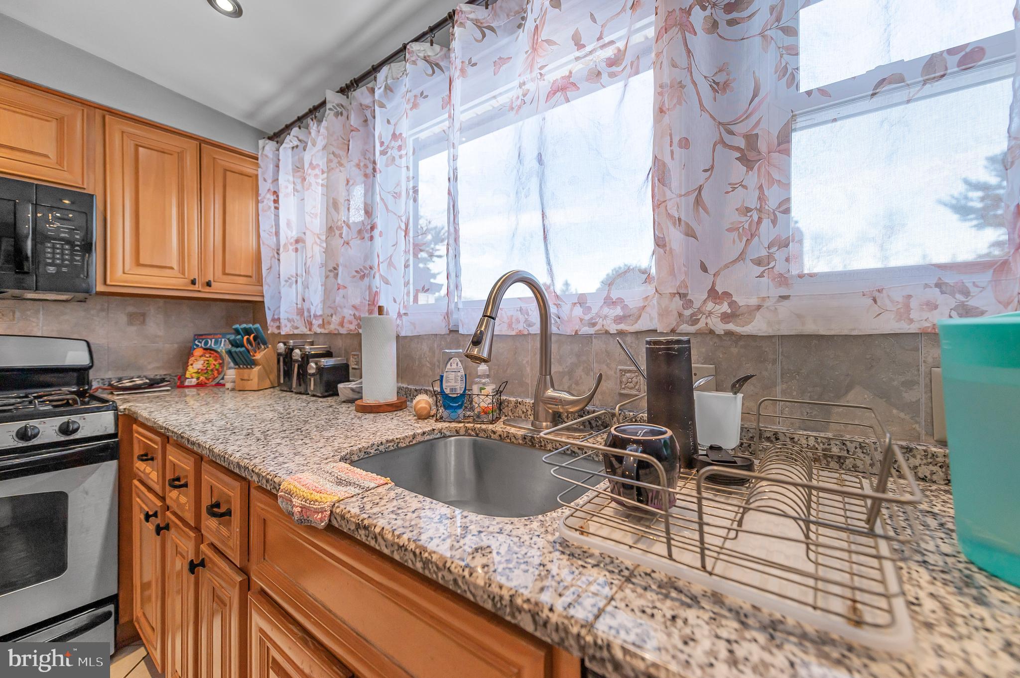 2409 Ashbourne Road Wyncote, PA 19095 - Photo 4 of 36 a kitchen with a sink a stove and cabinets