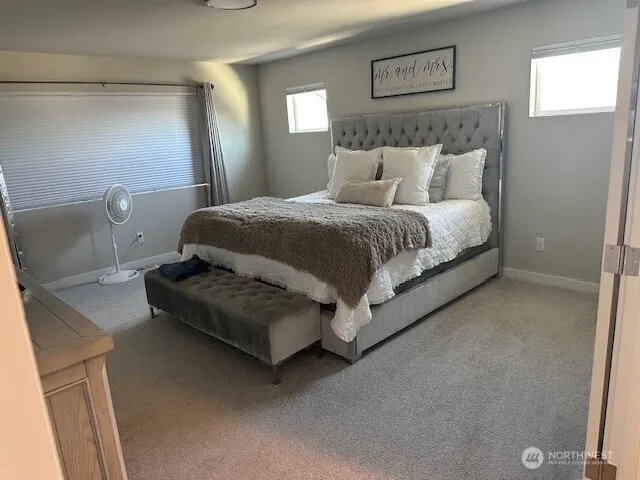 a bed sitting in a bedroom next to a window