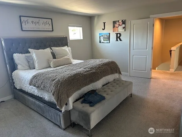 a bedroom with a bed and painting on the wall