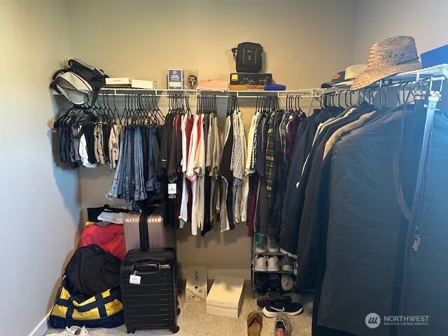 a view of walk in closet with clothes and shoes