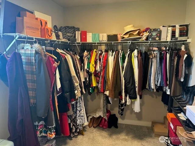 a view of walk in closet with clothes