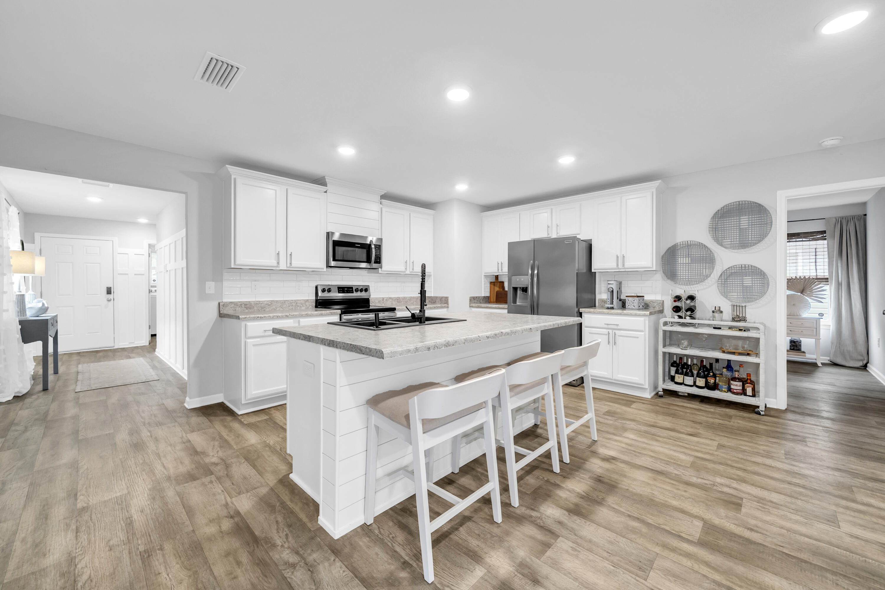 605 Earl Godwin Road Freeport, FL 32439 - Photo 3 of 47 a kitchen with stainless steel appliances granite countertop a stove top oven a sink dishwasher and a refrigerator with wooden floor