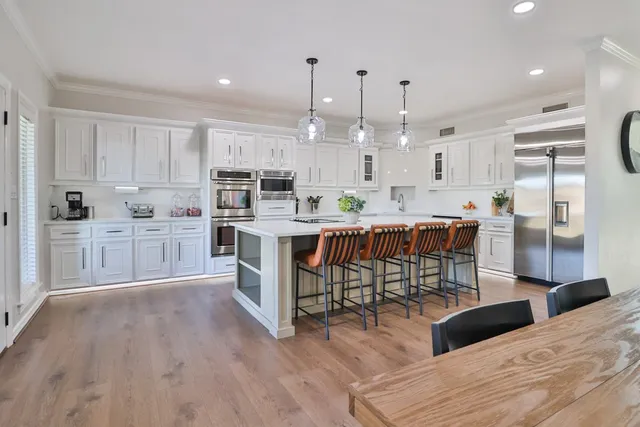 a kitchen with cabinets wooden floor and stainless steel appliances