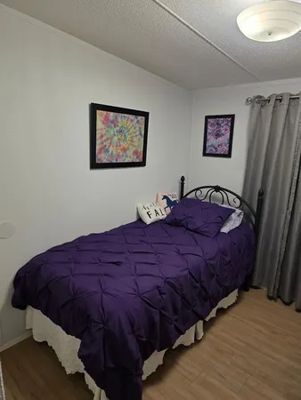 a bedroom with bed and a mirror
