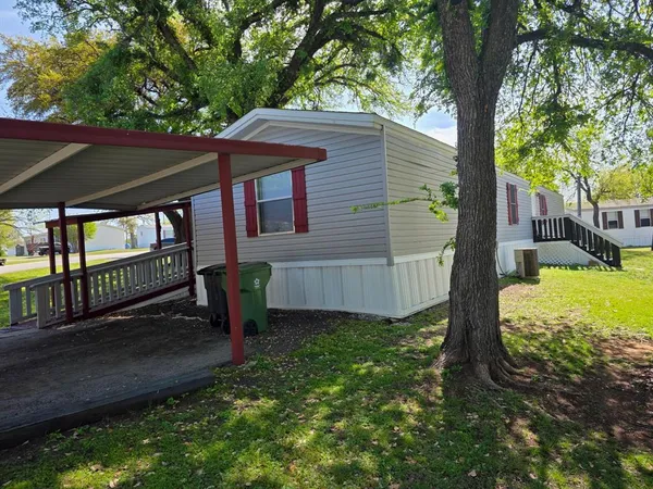a view of a house with backyard and a tree
