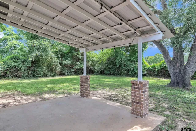 a view of a house with backyard and a tree