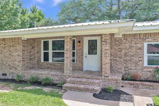 a view of a house with a yard and potted plants