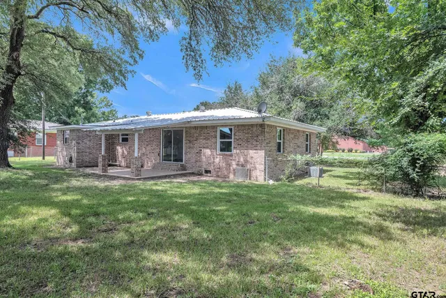 a front view of a house with yard patio and green space