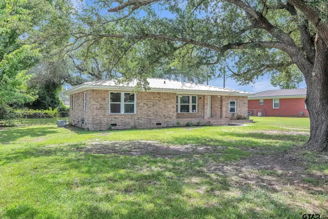 a view of a house with backyard and garden