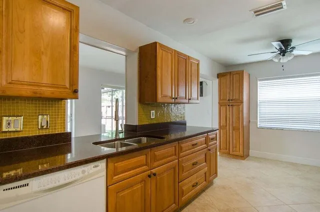 a kitchen with stainless steel appliances white cabinets and a stove top oven