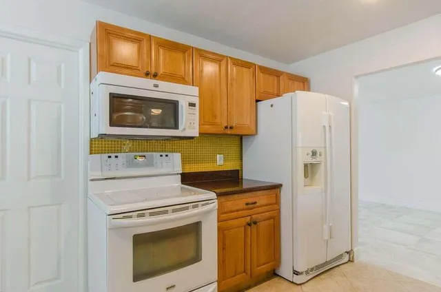 a kitchen with stainless steel appliances granite countertop a refrigerator and a stove