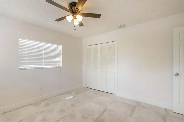 a bathroom with a granite countertop sink toilet a mirror and shower