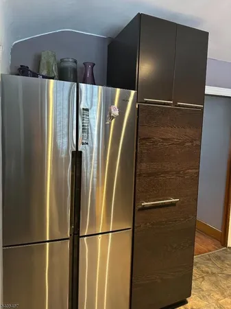 a metallic refrigerator freezer sitting in a kitchen