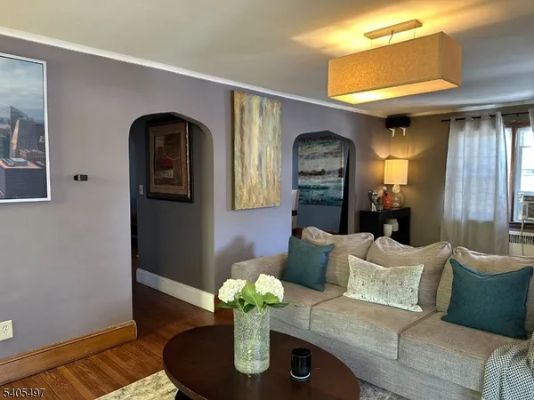 a living room with furniture flowerpot and wooden floor