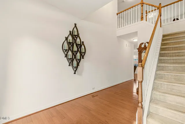a view of staircase with wooden floor and a chandelier